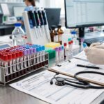 Tubos de ensayo con muestras de sangre y formulario de analítica clínica en laboratorio para control hormonal.